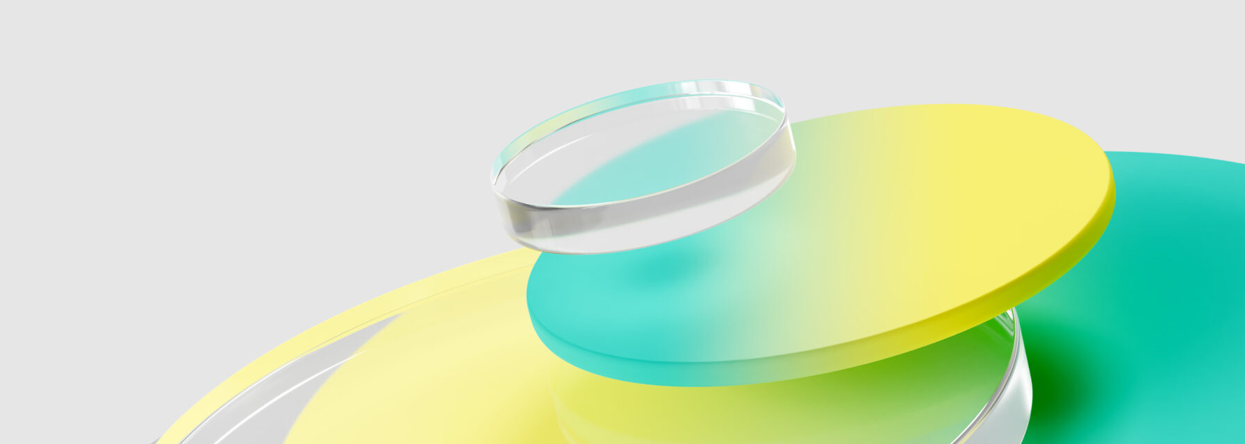 A stack of translucent, circular discs in yellow, green, and blue, topped with a clear cylindrical object, set against a light gray background