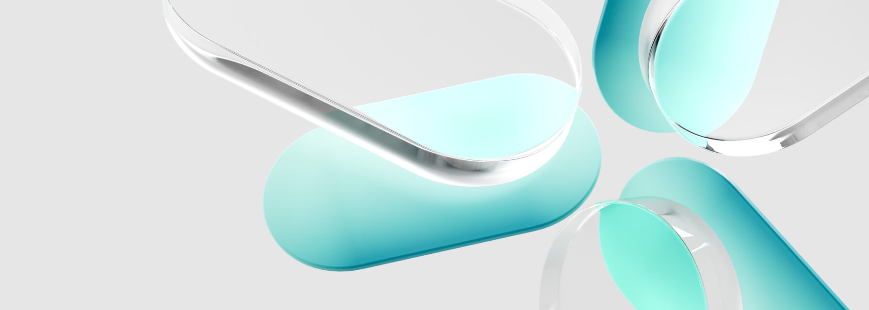 Close-up of four translucent, pill-shaped objects with rounded edges, arranged in a circular pattern with their ends pointing toward the center.