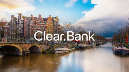Scenic canal view in Amsterdam featuring tall, narrow Dutch buildings with gabled roofs along the waterway