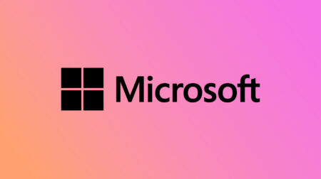 The Microsoft logo, featuring a black square divided into four smaller squares, followed by the word "Microsoft" in black text, set against a gradient background of pink and orange hues.