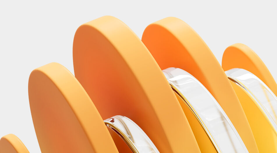 Close-up of several orange, curved objects with smooth surfaces, arranged vertically in a row.