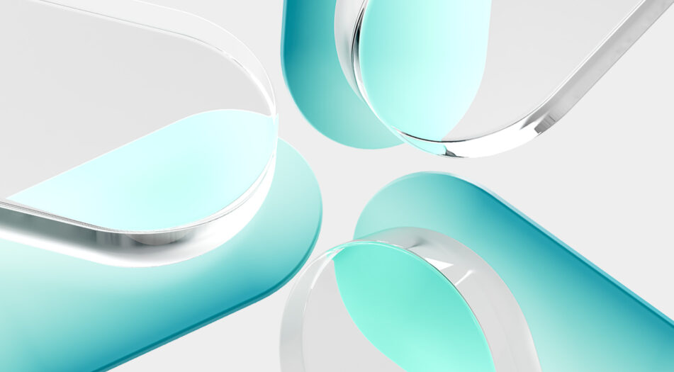 Close-up of four translucent, pill-shaped objects with rounded edges, arranged in a circular pattern with their ends pointing toward the center.